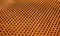 Perforated rusty iron sheet texture. Surface of industrial mesh with depth of field. Horizontal corrosion background