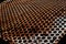 Perforated rusty iron texture. Surface with depth of field, abstract industrial mesh background