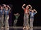 Performance of a children`s dance group in shiny costumes, in the style of disco at the open festival of creativity