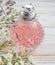 Perfume bottle, flower composition summer essence trend fragrant on wooden background product