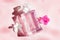 A perfume bottle and a flower on a pink background . Smell. Aromatherapy. Pink violet. Copyspace Perfume