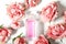 Perfume bottle in pink flower roses. Spring background with luxury aroma parfume. Beauty cosmetic shot