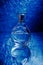Perfume bottle with reflection on blue
