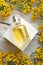 Perfume bottles around yellow flowers at  wooden old style background . flat lay. perfumery concept