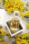 Perfume bottles around yellow flowers at  wooden old style background . flat lay. perfumery concept