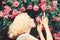 Perfume and cosmetics. Woman in front of blooming roses bush. Blossom of wild roses. Secret garden concept. Aroma of