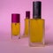 Perfume with yellow liquid on a pink solid background, watches, women`s fashion