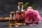 Perfumed rose water in a glass small bottle with wooden stopper. Pink flower petals oil. Massage, aromatherapy and organic