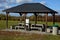 Pergola, garden pavilion is equipped with a metal grill. public barbecue place in the park. the pergola is equipped with tables an