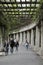 A pergola in Wroclaw, people are resting while walking along a corridor made of columns