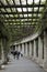 A pergola in Wroclaw, people are resting while walking along a corridor made of columns