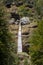 Pericnik waterfall with water falling  down a mountain, seen from below, with a blue sky in summer.