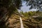 Pericnik waterfall with water falling down a mountain, seen from below, with a blue sky in summer.