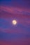 Perigee Moon Supermoon surrounded by purple clouds at sunset with a dark blue sky