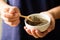 Perilla seeds in a bowl with spoon holding by hand