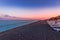 Perissa, beach at sunset, Santorini, Greece with beautiful beach huts, blue sky and clouds