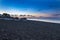 Perivolos beach on Santorini island in Greece at sunrise. The background is a blue sky with white clouds