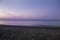 Perivolos beach on Santorini island in Greece at sunrise. The background is a blue sky with white clouds