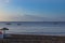 Perivolos beach on Santorini island in Greece at sunrise. The background is a blue sky with white clouds