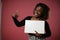 A perky black woman holds a white sign.