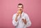 Perky cool guy in white bathrobe is standing on wall back with fragrant croissant