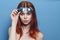 perky red-haired woman in blue glasses bare shoulders posing