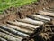 Permaculture trench construction close up with green grass side