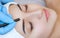 Permanent make-up for eyebrows of beautiful woman with thick brows in beauty salon.