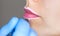 Permanent make-up for lips of beautiful woman in beauty salon. Closeup beautician doing lip tattooing. Face close-up. Make-up and