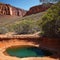 Permanent waterhole Ellery Creek Big Hole and geological site with red cliffs in West MacDonnell National Park, 80km