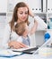 Perplexed girl with child is having issue while working behind laptop