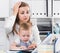 Perplexed girl with child is having problems while working
