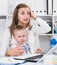 Perplexed mom with child is having issue while working behind laptop