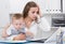 Perplexed mother with child is having issue while working behind laptop
