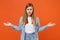 Perplexed puzzled young woman girl in casual denim clothes posing isolated on orange wall background studio portrait