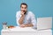 Perplexed young bearded man in shirt sit, work at desk with pc laptop isolated on pastel blue background. Achievement