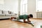 Perseverance matters. Young active man looking focused, exercising, doing plank during morning workout at home. Sport