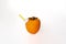 Persimmon, fruit on a white background, with a straw in the spout to be able to drink like a juice bottle, close-up