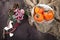 The persimmon in a plate on a napkin made of canvas on a dark wooden table