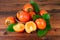 Persimmons with green leaves on old wooden background