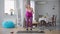 Persistent serious motivated obese woman lifting dumbbells training at home indoors. Wide shot front view of overweight