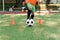 Persistent teen soccer player kicking ball on field. Close up feet of footballer kicking ball on green grass.