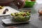 Person adding ingredients into a salad in a plastic bowl and weighing it for delivery