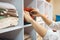 a person adjusts knitted things on a shelf