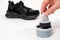 A person applies sponge paint cream to the black crumbs of the child. Care for children& x27;s leather and suede shoes.