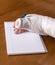 Person with an arm cast writing a note