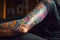 Person arm that is covered in colorful tattoos. Generative AI
