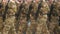Person army uniform with machine gun in their hand closeup marching slowmotion