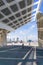 Person on bicycle passing under the photovoltaic pergola of the Barcelona Forum on a sunny day