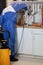 Person in a blue costume and an anti-gas mask doing a sanitary inspection in the kitchen